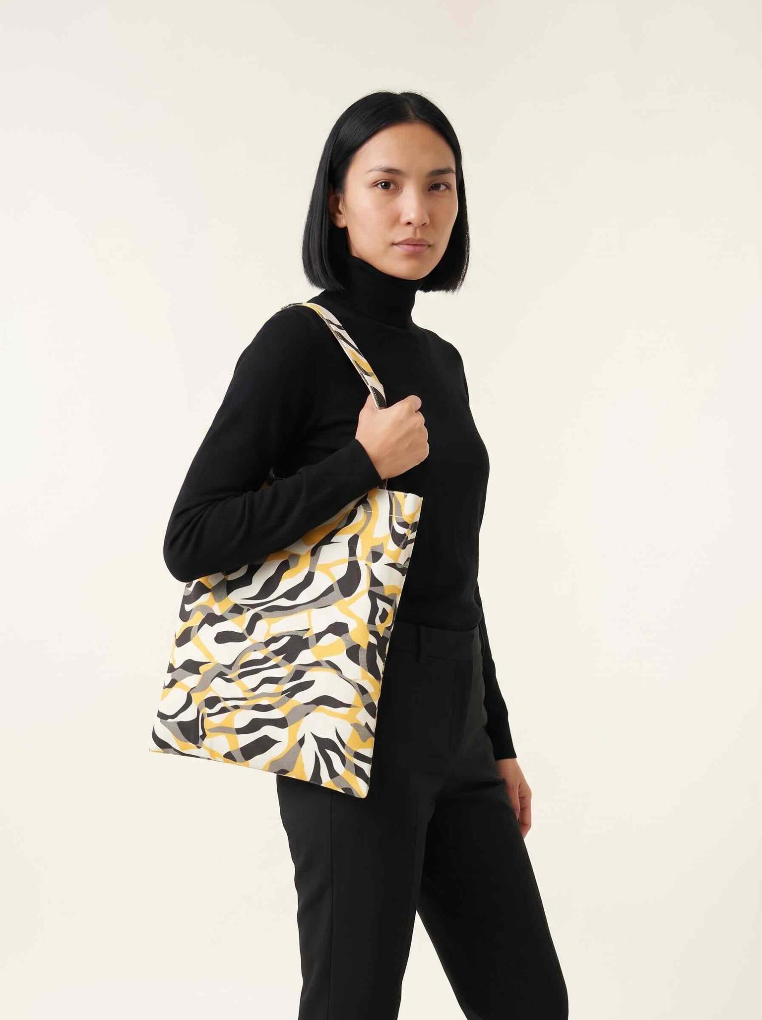 Campaign image of the same model wearing the uploaded handbag